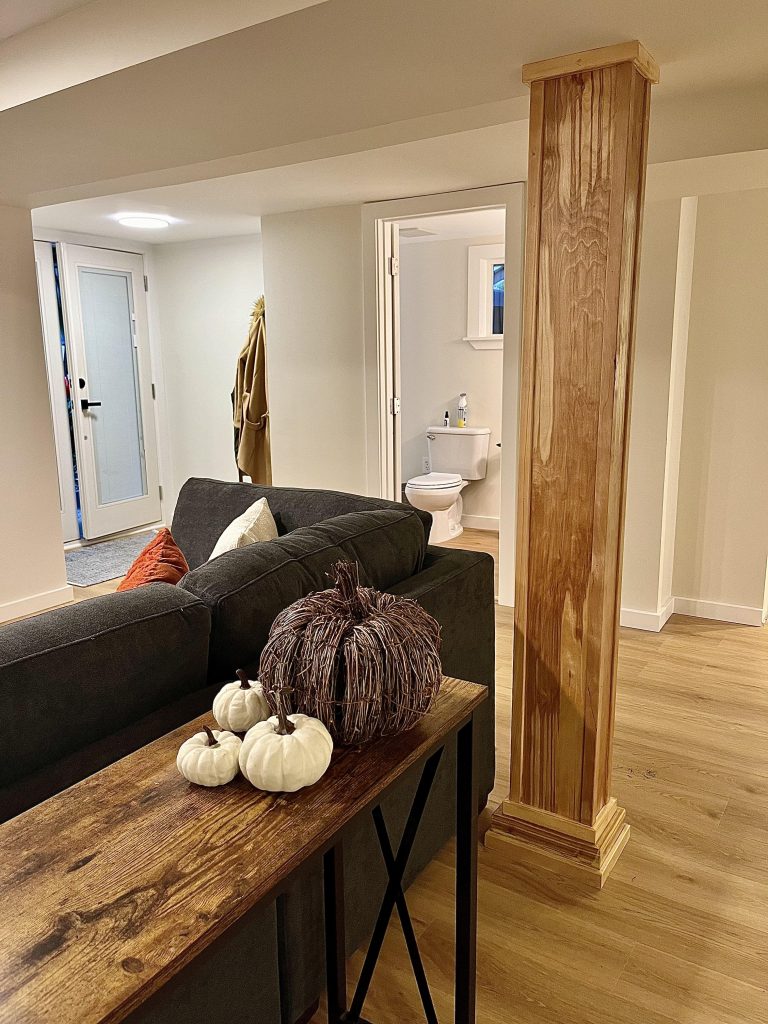 A finished basement conversion considered fine details, such as wood accents to cover support beams.