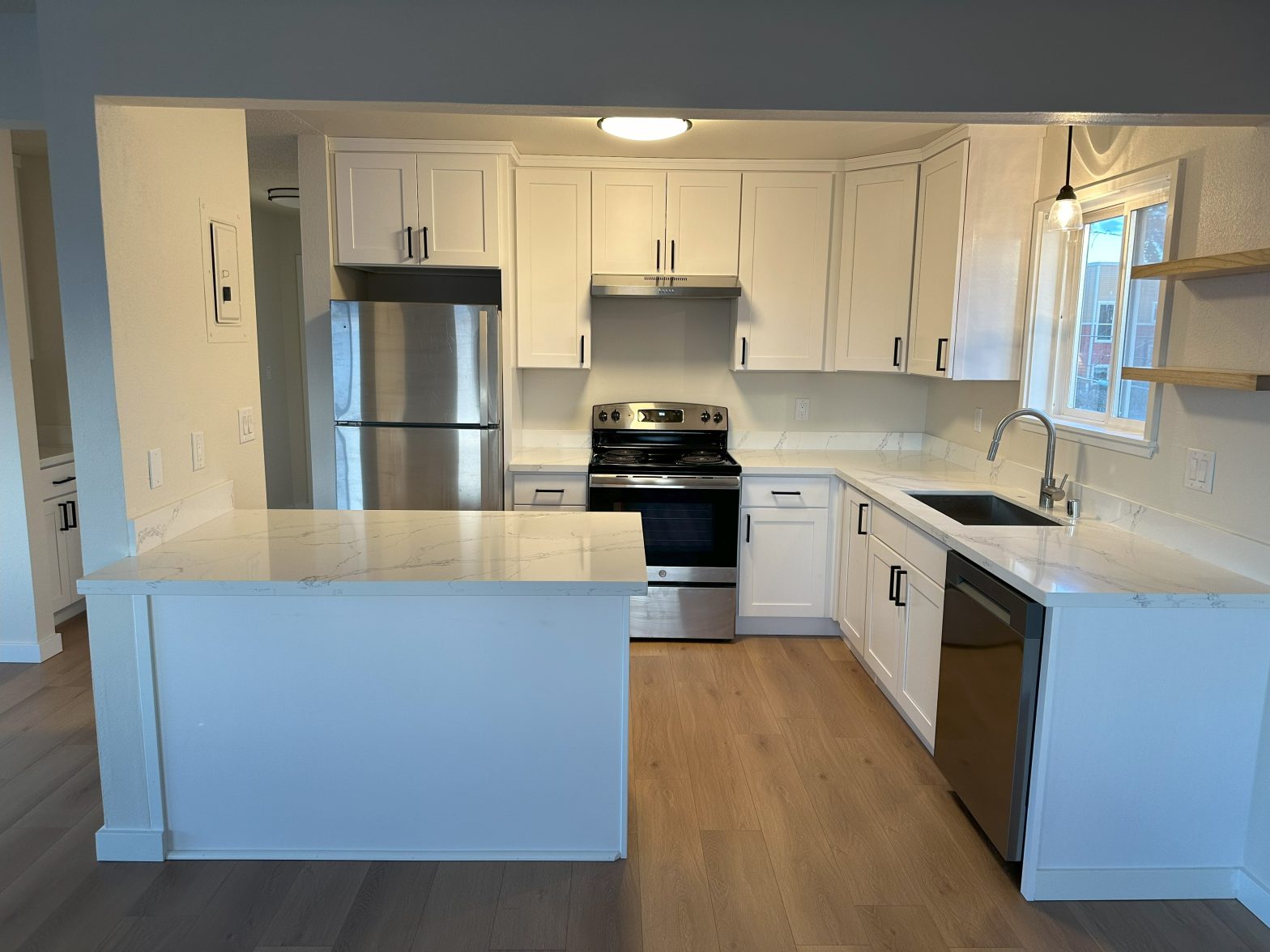 A white kitchen with stainless steel appliances and black accents.