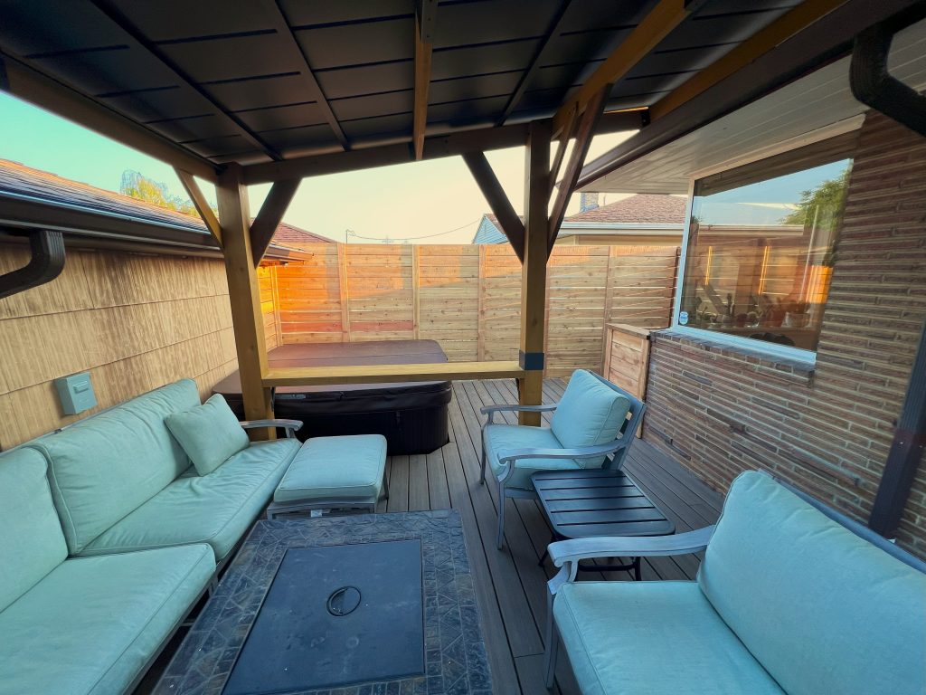Plush patio furniture transform the backyard deck with roof into an extended living space.