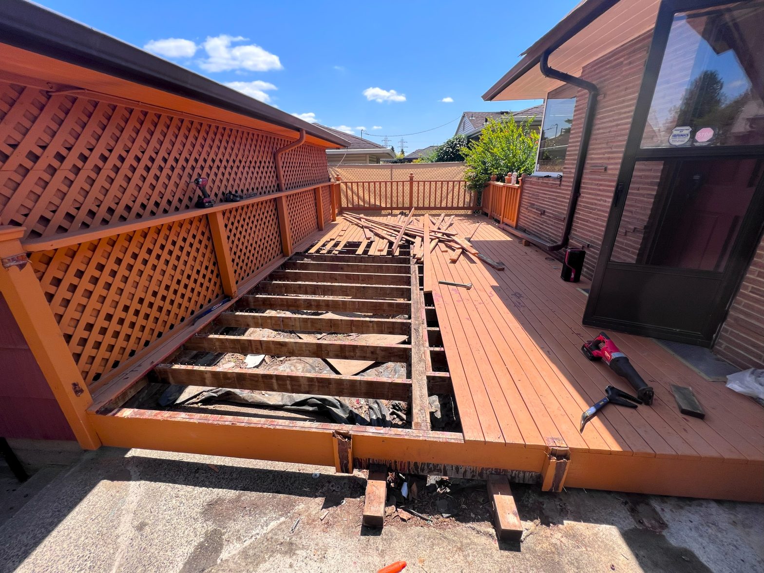 Nearly half the planks of an old wood deck are removed in the early stages of a deck rebuild.