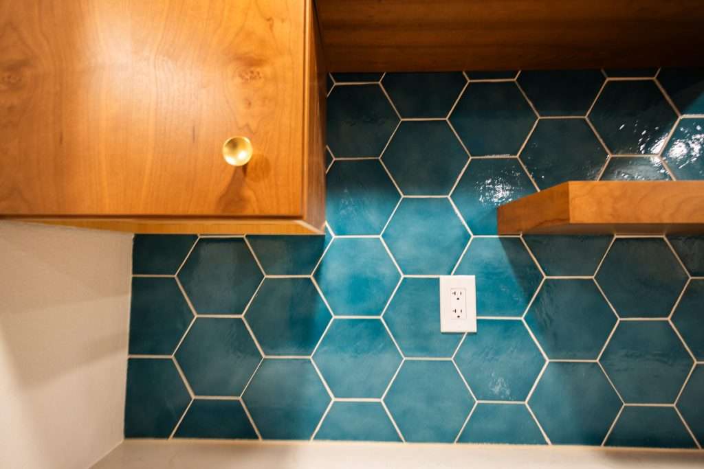 Hexagonal turquoise tiles with wooden hanging cabinets