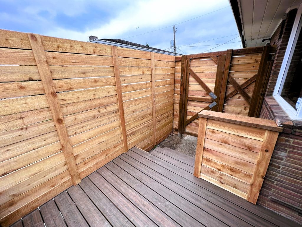 A custom privacy fence, gate, and hand rail surround the rebuilt wood deck.