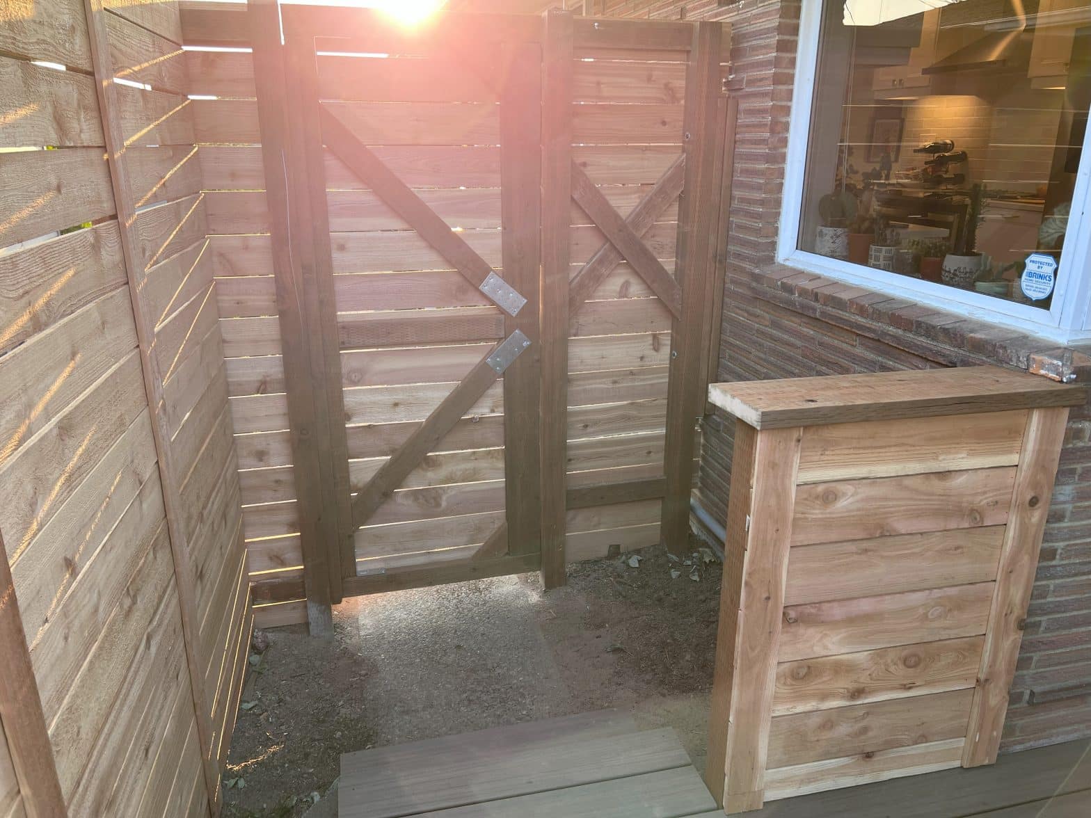 A wood fence with a gate and hand railing