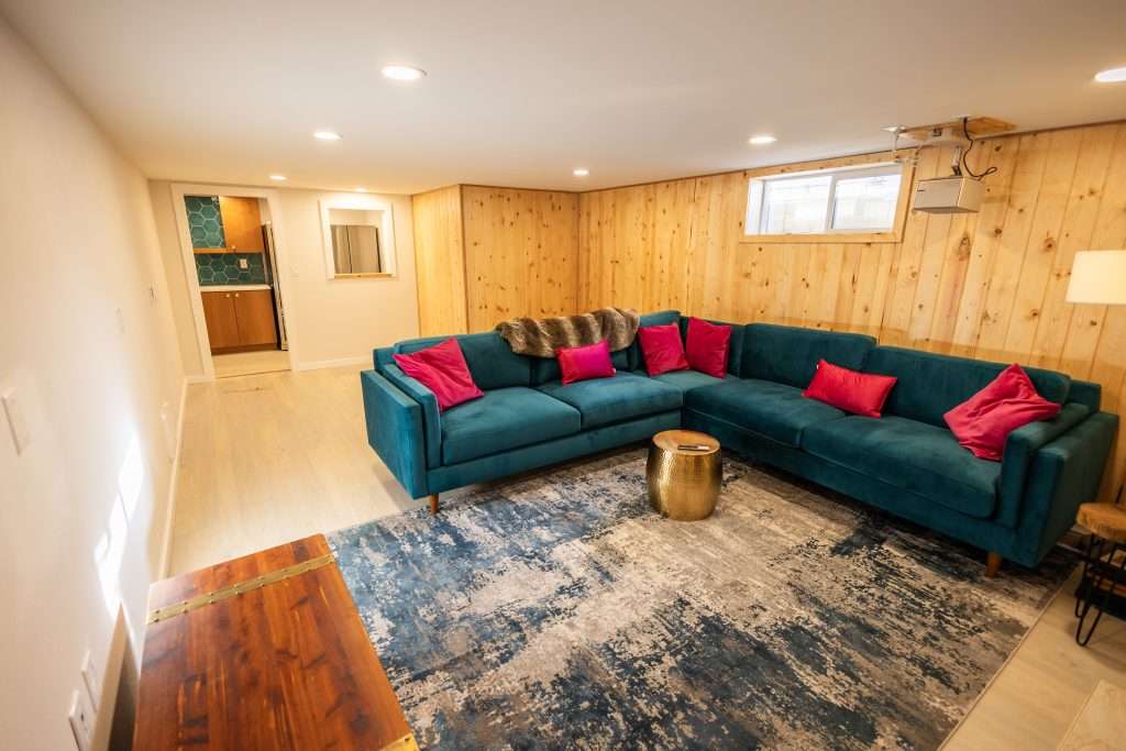 A cozy basement living room with wood paneling and recessed lighting.