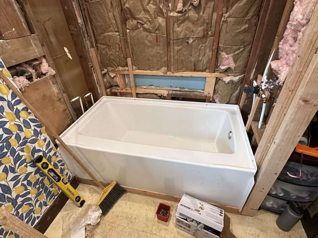 A new bathtub install in a small bathroom renovation project.