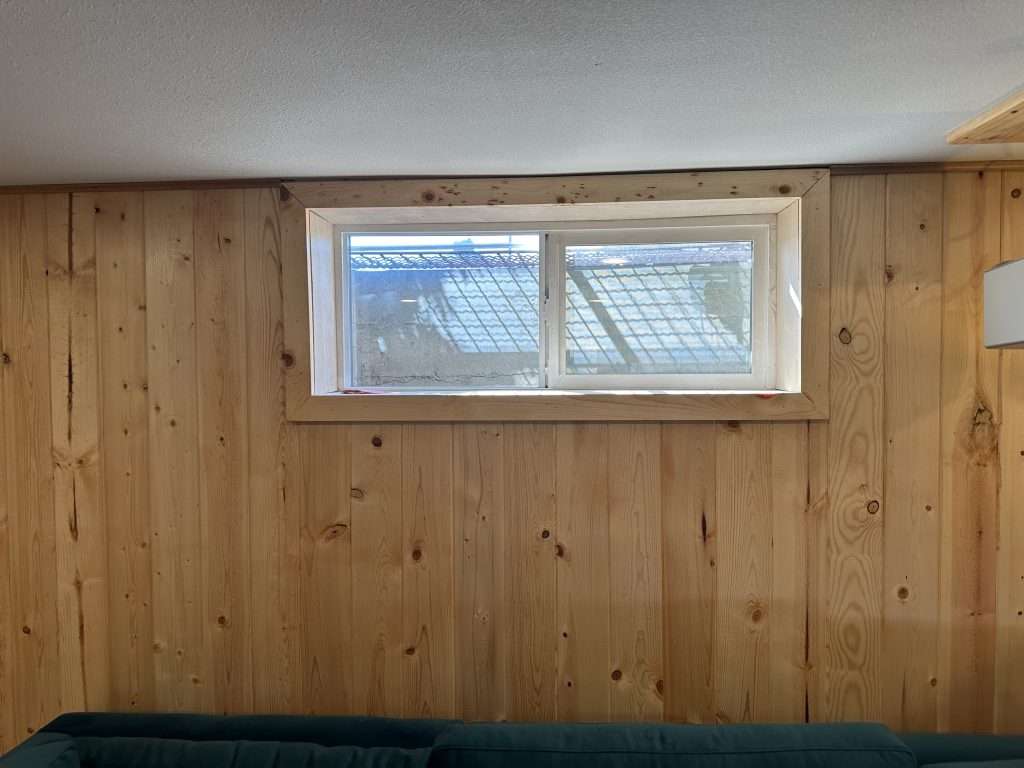 An egress window provides daylight and ventilation for the finished basement.