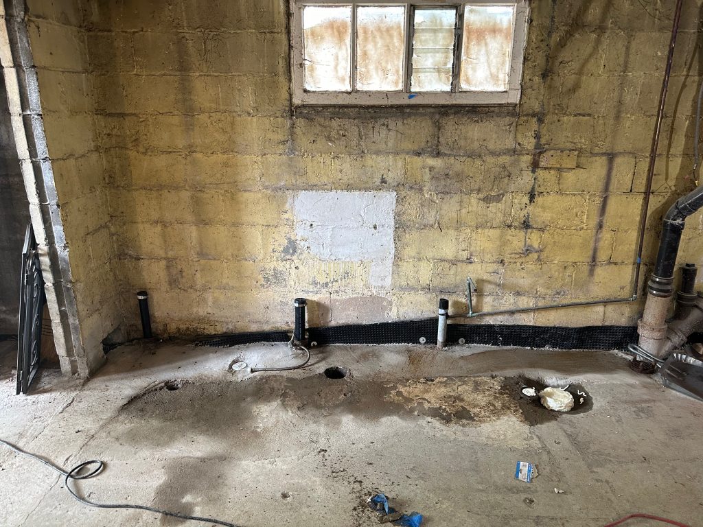 An unfinished basement with signs of water intrusion.