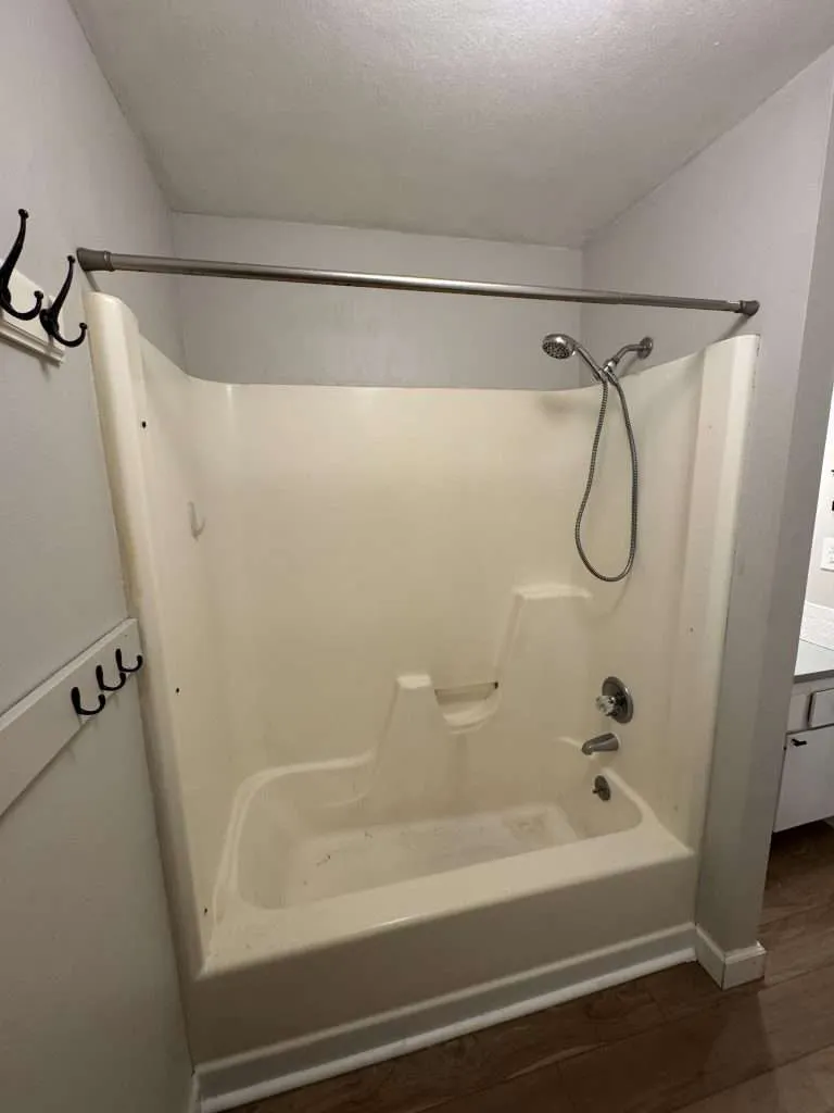 basic bathroom with shower tub and wall hooks