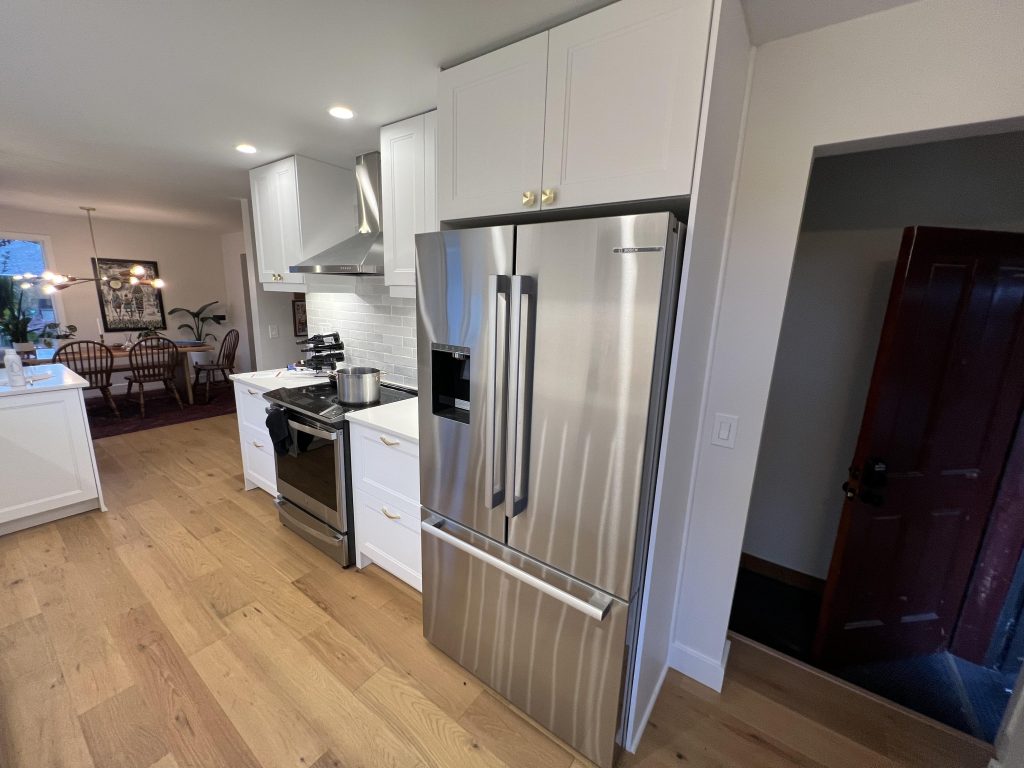 New laminate wood floors, recessed lighting, and stainless steel appliances were modern upgrades in a Seattle kitchen remodel.