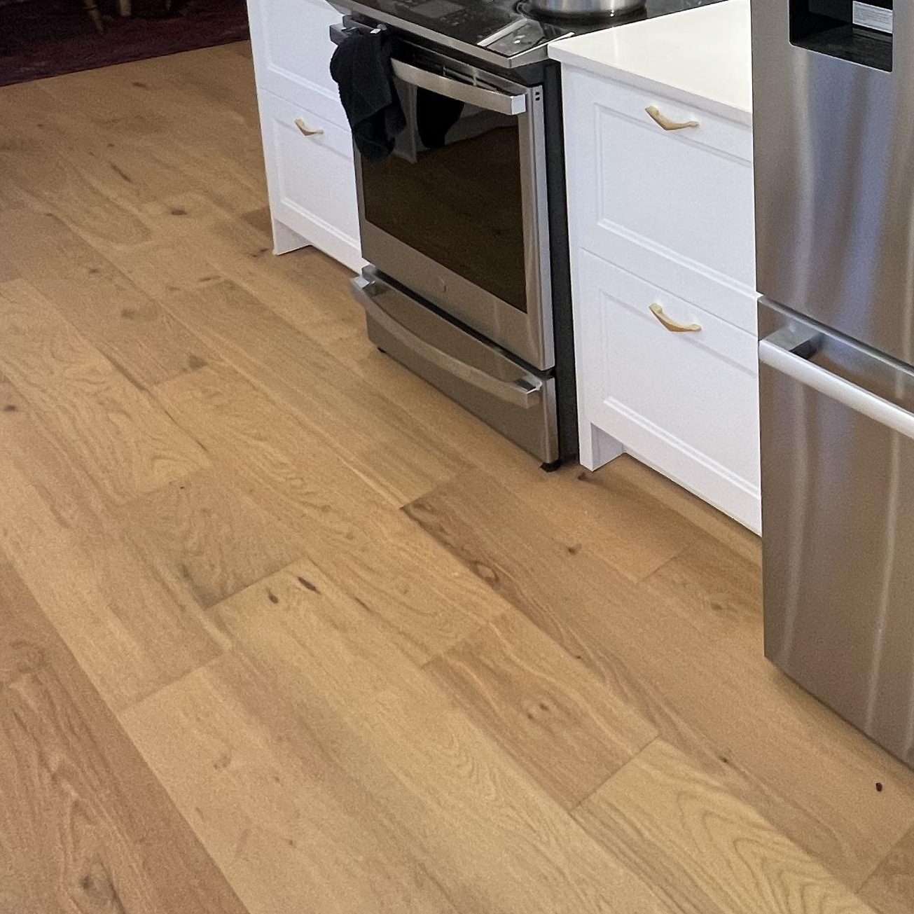 New laminate wood floors, recessed lighting, and stainless steel appliances were modern upgrades in a Seattle kitchen remodel.