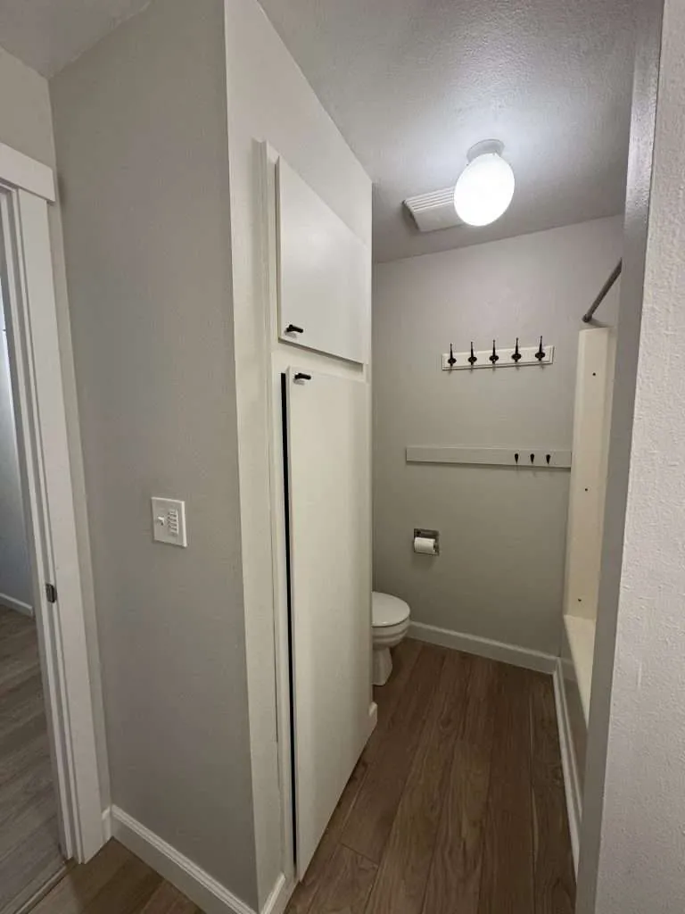 small bathroom with wood floor and built in cabinet
