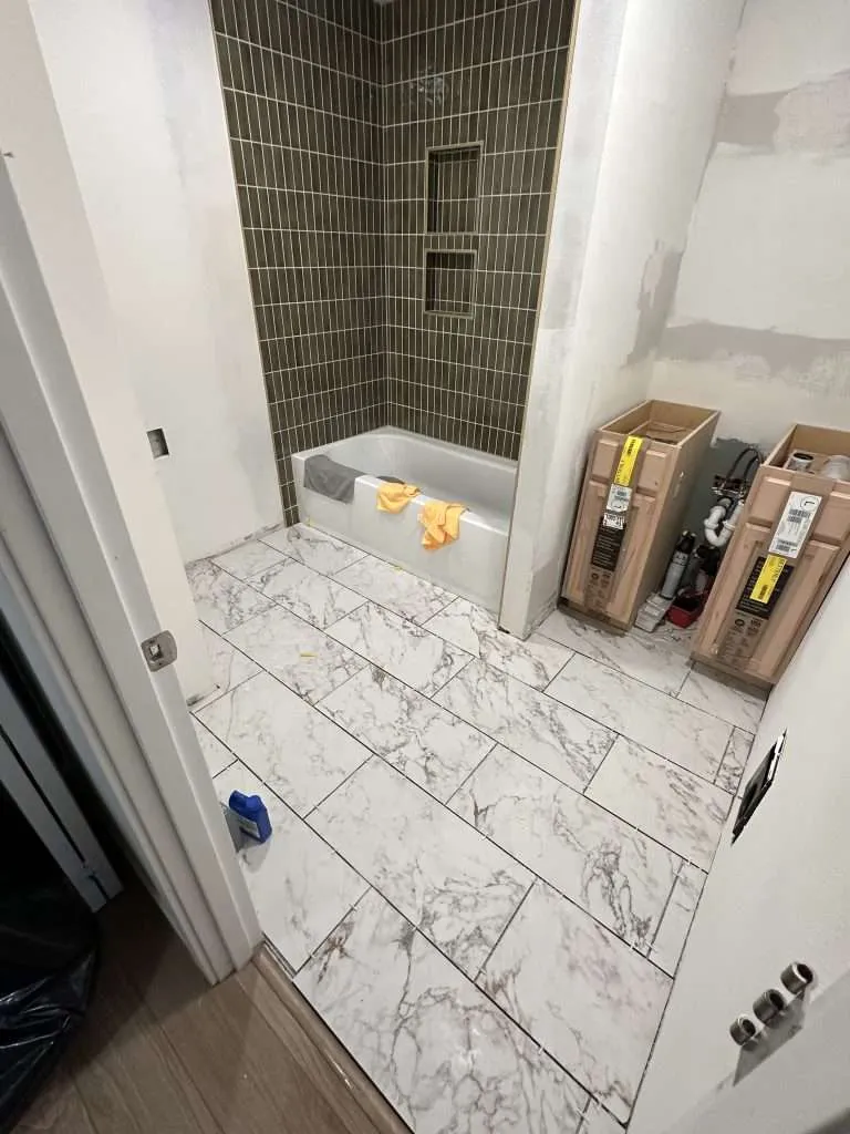 tiled bathtub surround paired with marble flooring
